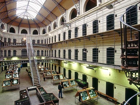 De Kilmainham gevangenis Deze fascinerende gevangenis in Dublin laat de hartverscheurende moed zien van de mannen en vrouwen die de Engelse overheersing bevochten en hielpen om een onafhankelijk land op te richten De Kilmainham gevangenis geopend in 1796 speelde een rol in elke opstand in de daaropvolgende 128 jaar vele Ierse leiders zaten hier gevangen tot en met de Ierse onafhankelijkheidsoorlog 19191921 Het vuurpeloton dat de 14 leiders van de Paasopstand uit 1916 executeerde in de gevangenistuin betekende een keerpunt en creerde verontwaardiging en steun voor het nationalisme De kleurrijke rondleiding vertelt de verhalen van vele gevangenen zoals dat van Joseph Plunkett die met zijn liefje trouwde in de kapel van de gevangenis vlak voor hij voor het vuurpeloton moest verschijnen en dat van James Conolly die niet eens meer kon staan door zijn verwondingen en daarop op een stoel werd gebonden voor zijn executie Het strenge grijze gebouw is een van de grootste onbewoonde gevangenissen van Europa en laat de primitieve omstandigheden zien zoals ze toen waren In de afgelopen jaren was ze het decor van films zoals Michael Collins 1996 en In the Name of the Father 1993