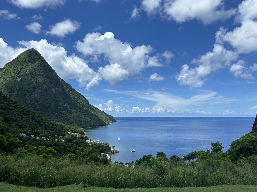 coastal view with mountains clouds and a sailboat