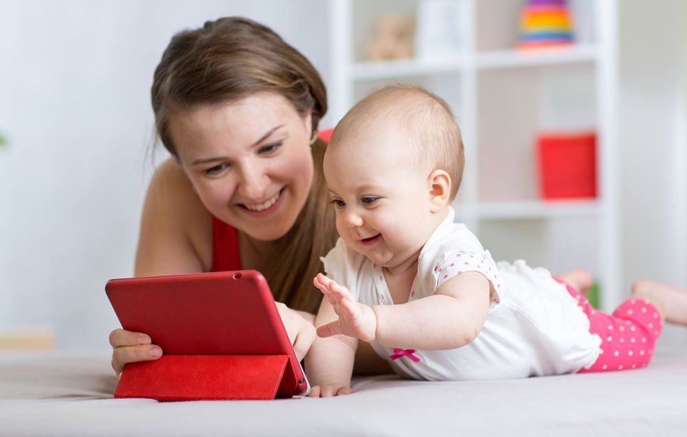 A mom and baby looking at an ipad