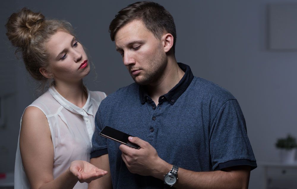 A man handing his phone to a woman
