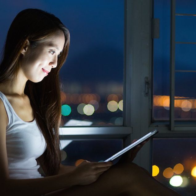 woman on tablet at night