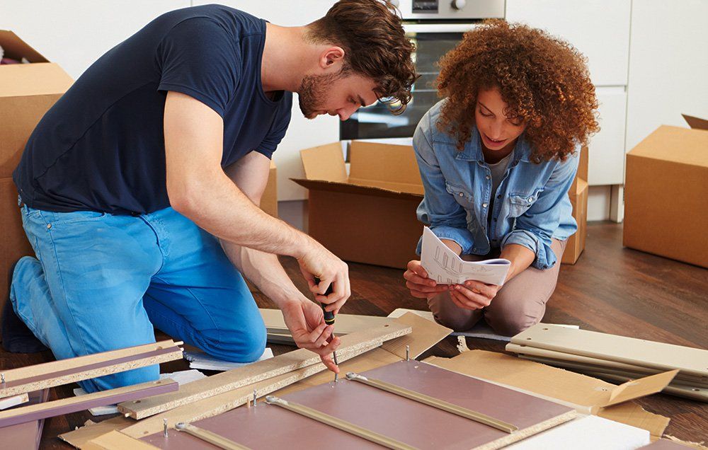 Two people building IKEA furniture