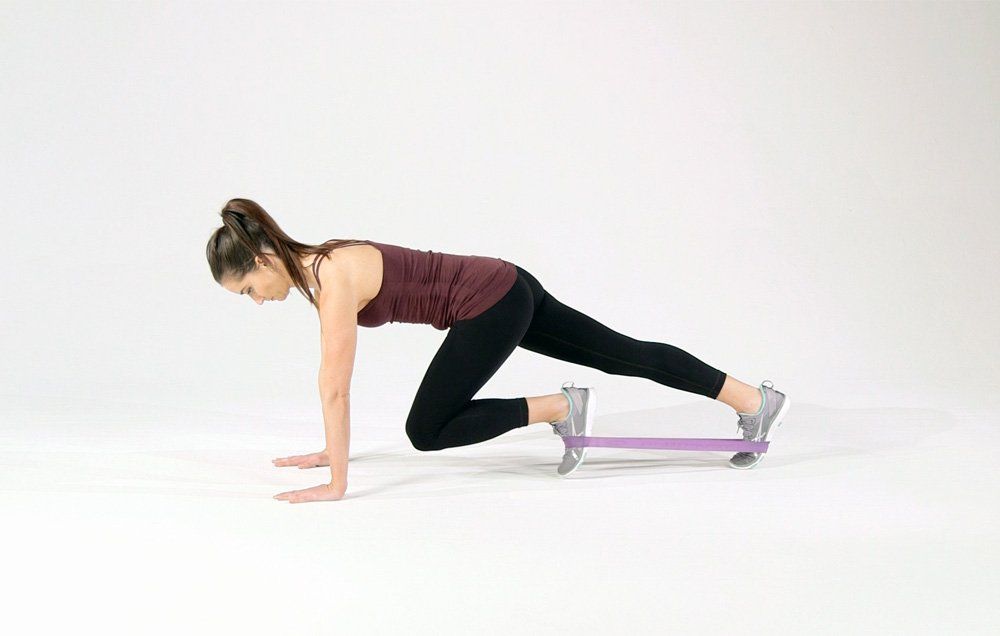 fit and flexible woman doing mountain climbers exercise 