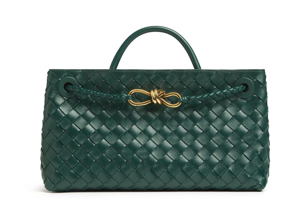a green handbag with a gold ring on it