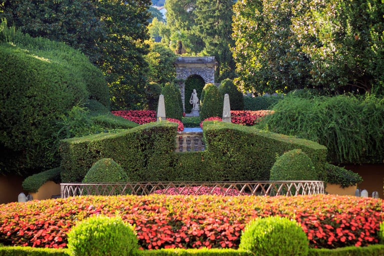 Formal garden featuring manicured hedges and colorful flowers Formal garden featuring manicured hedges and colorful flowers