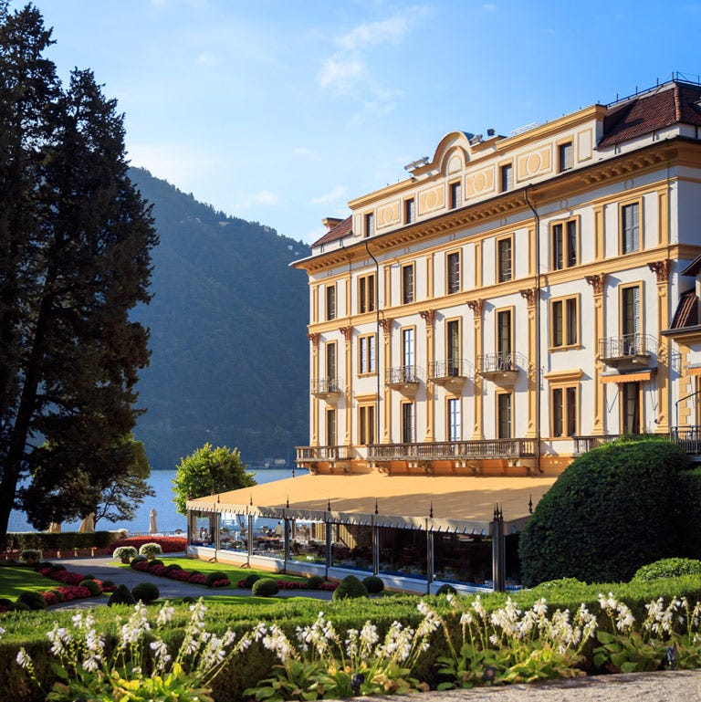 Luxurious hotel exterior overlooking a lake with landscaped gardens Luxurious hotel exterior overlooking a lake with landscaped gardens