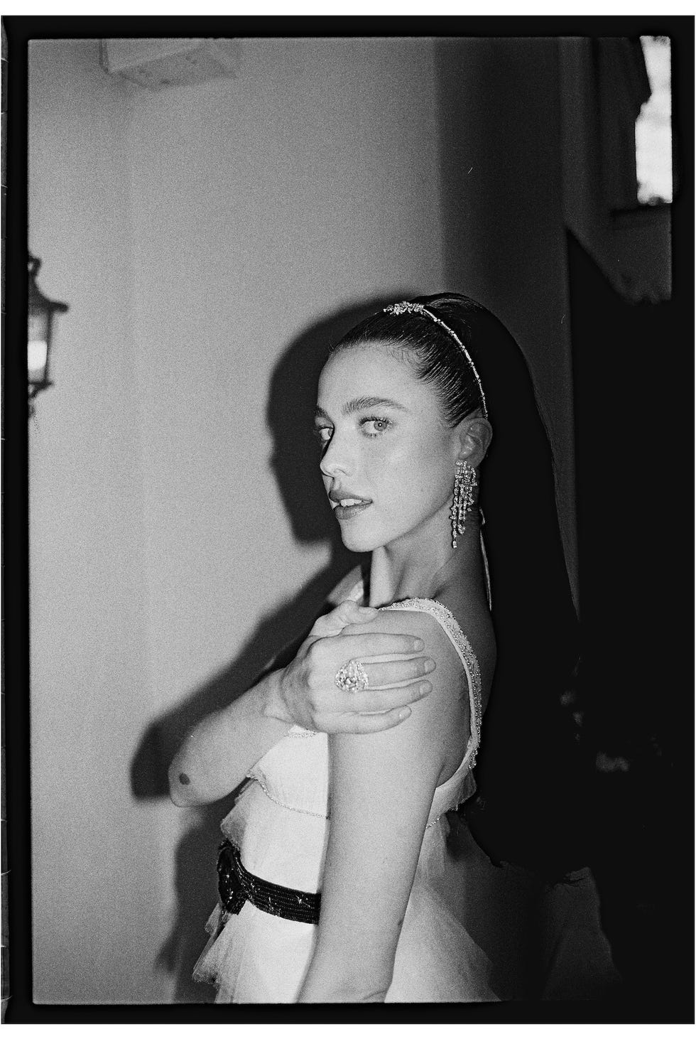 a woman in elegant attire posed gracefully against a neutral background