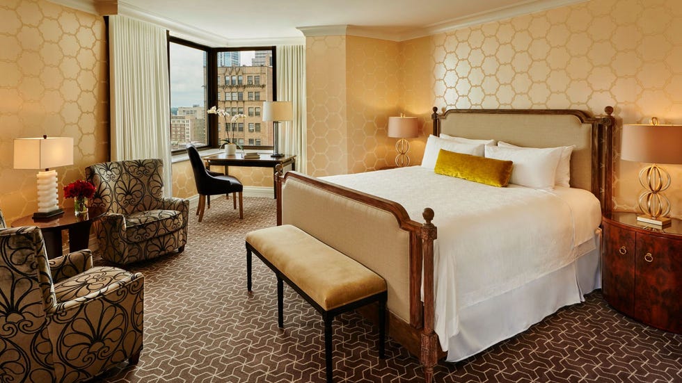 hotel room with king bed seating area and desk by the window