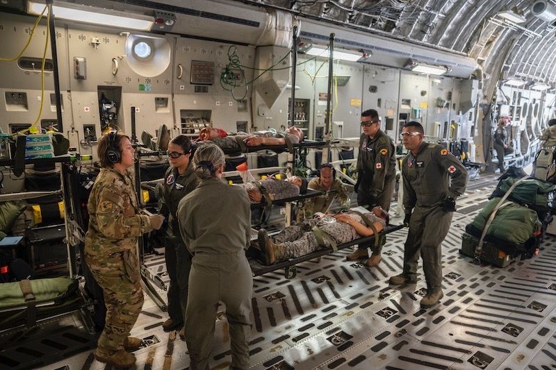 colombia aerospace force and us air force medical personnel hoist a litter with a simulated aircraft crash patient in a c 17 globemaster iii assi