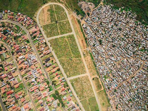 De begraafplaats van Mooifontein scheidt de township Vusimuzi van de welgestelder nieuwbouwwijk Tembisa In ZuidAfrika schommelt de levensverwachting rond de zestig jaar hoewel dat cijfer voor bewoners van townships vaak lager ligt