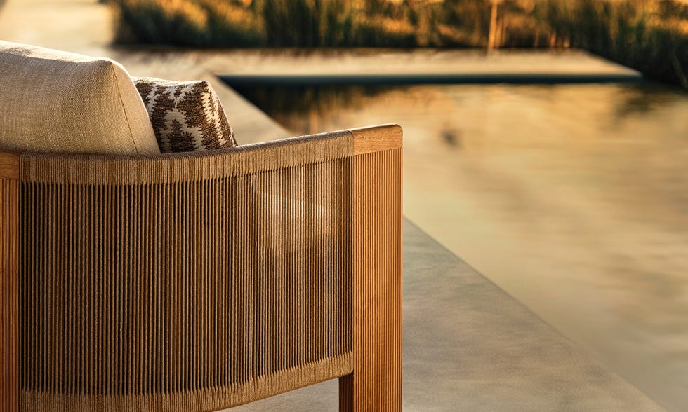 Outdoor seating area with a modern chair and decorative cushions.
