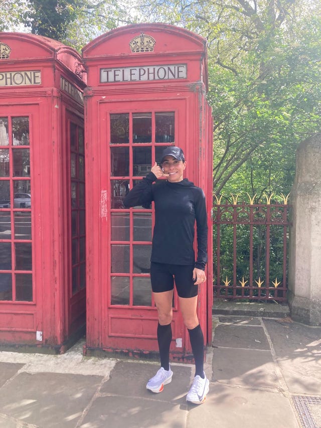 a person standing in front of a red telephone booth