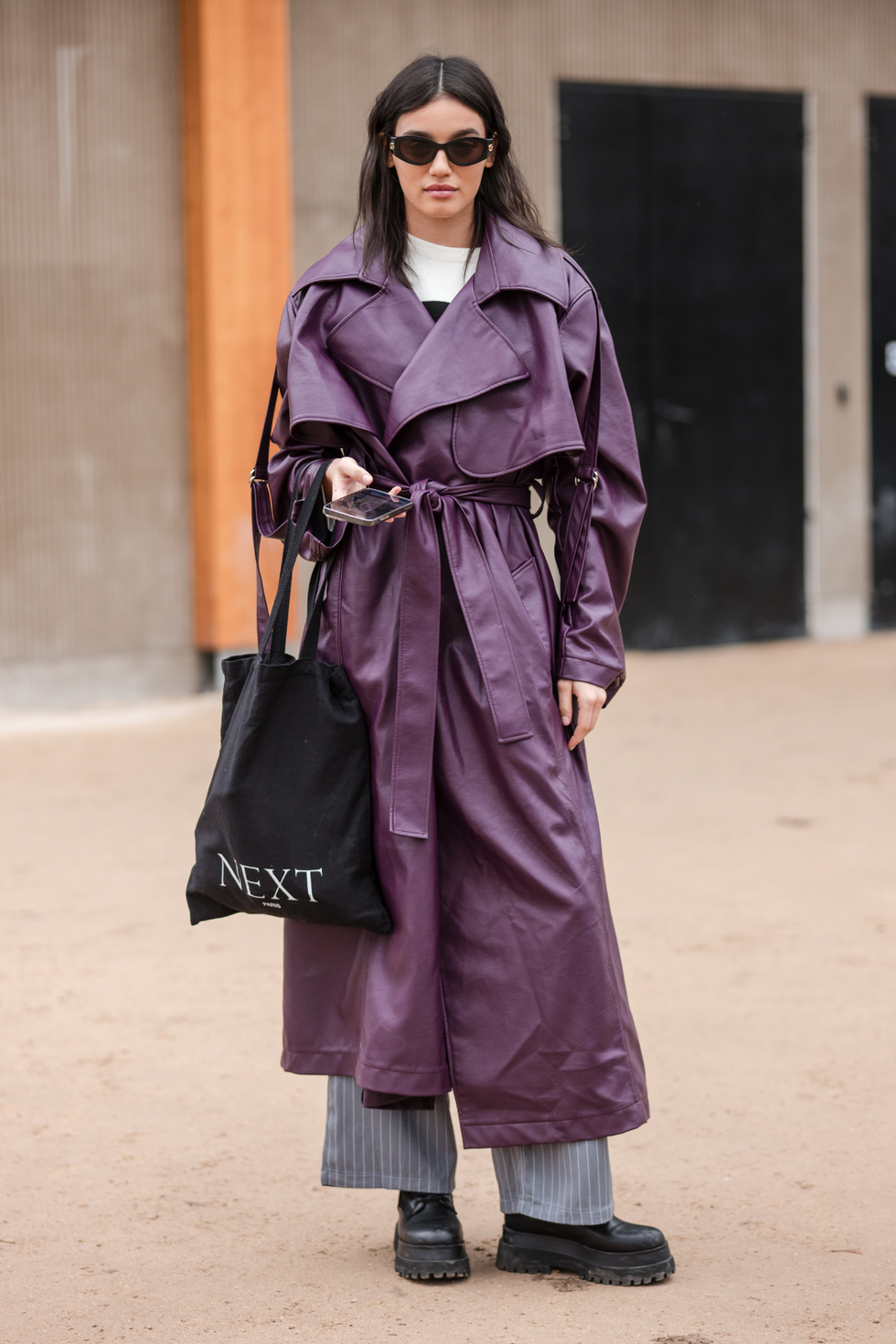 a woman wearing a purple coat and sunglasses