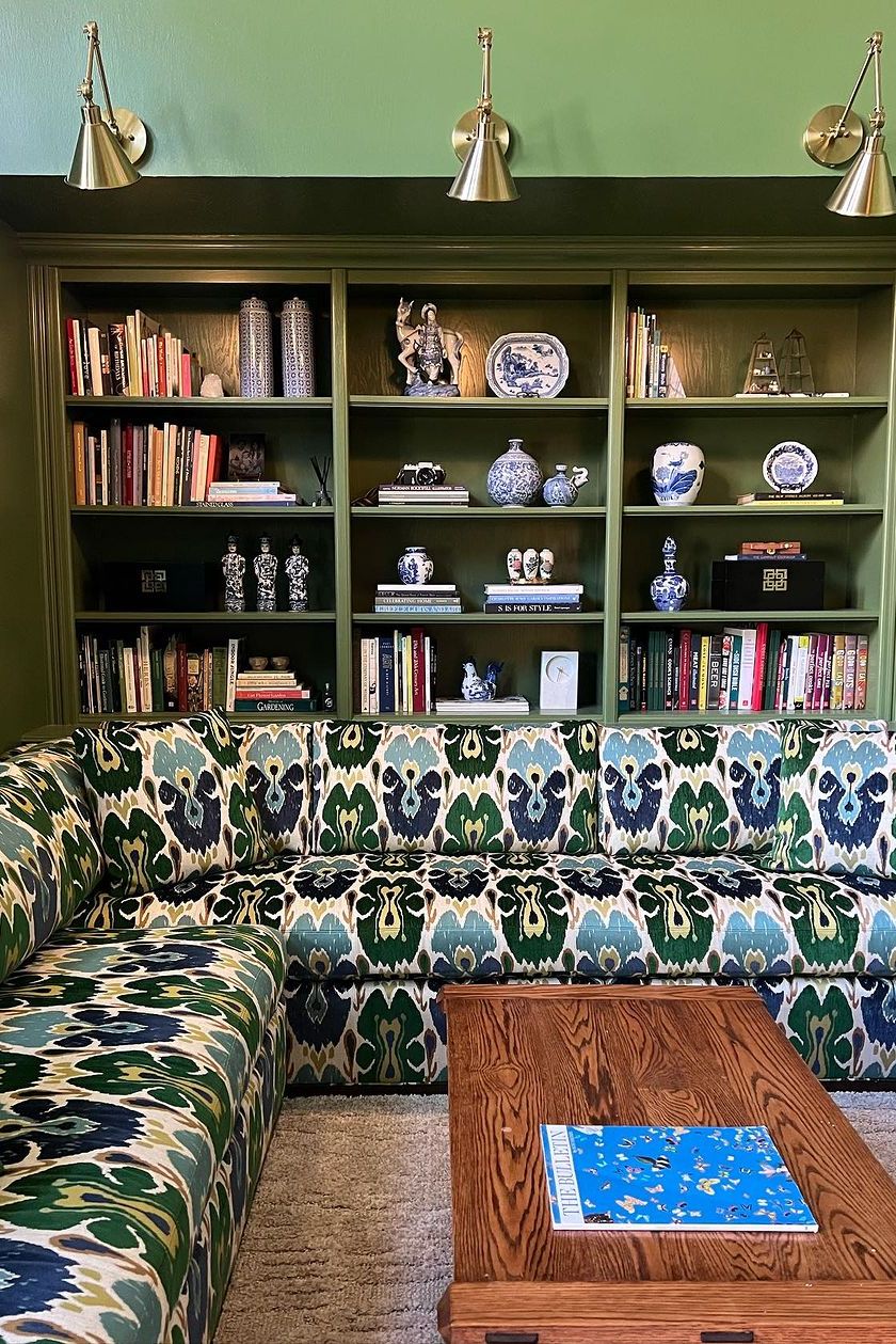 green wall with books and coffee table