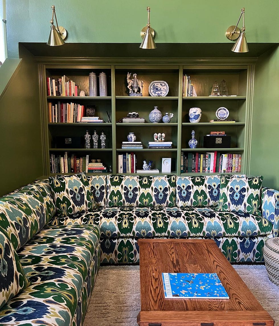 green wall with books and coffee table