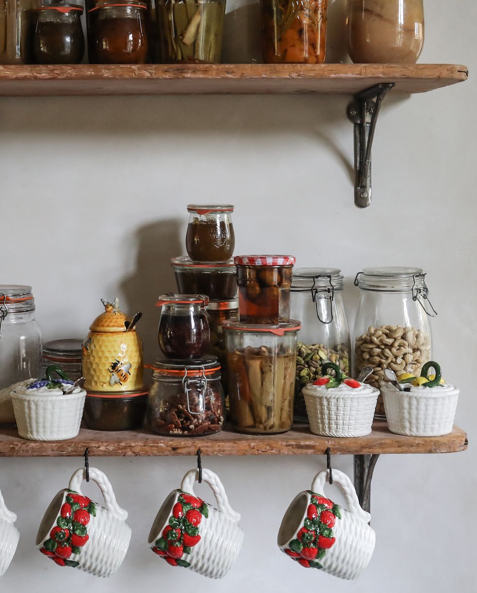 rustic wooden kitchen shelving with food storage jars and crocker