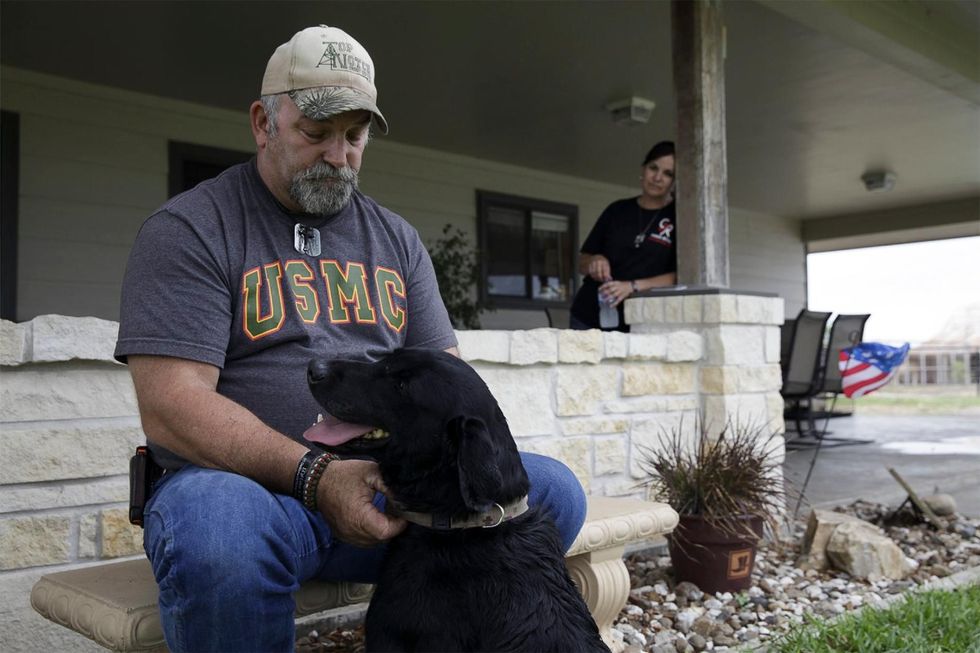 Darrell Rusk de vader van Colton zit samen met Eli op de veranda van hun huis in Texas Hij draagt de identiteitsplaatjes van Colton om zijn nek
