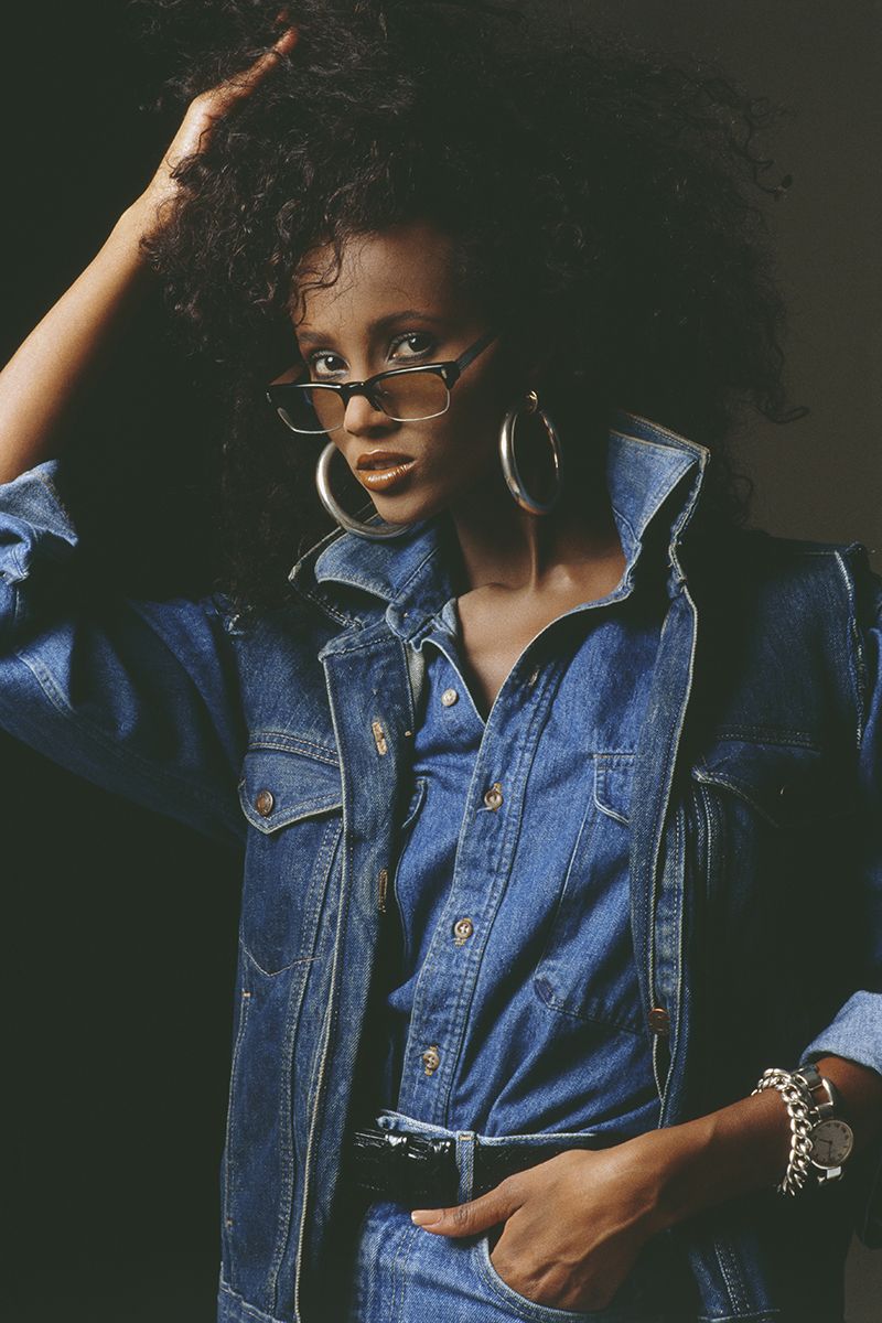80s outfit worn by Iman, showing the model wearing trip denim with big silver hoop earrings and tinted sunglasses