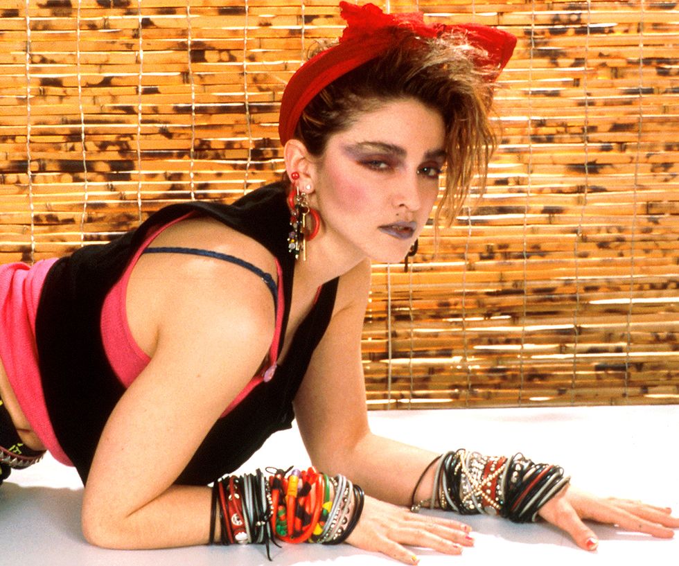 80s fashion trends worn by Madonna, including stacked bracelets, heavy eye makeup, statement earrings and fabric through her hair