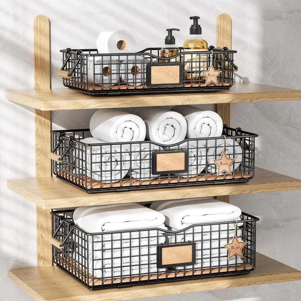 organized storage with rolled towels and toiletries in black wire baskets