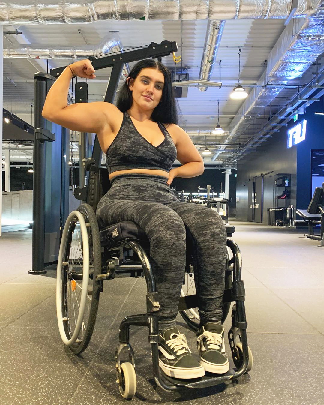 social media influencer sophie butler flexing muscles in wheelchair at the gym