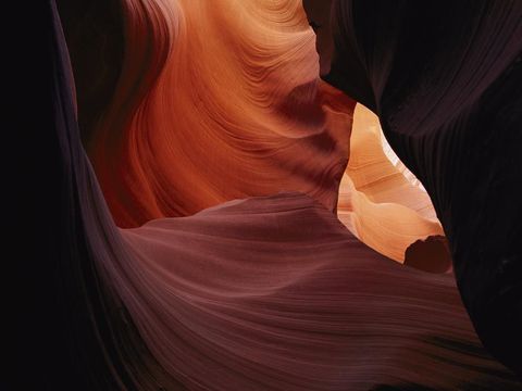 Zonlicht dringt door in spleten van de Antelope Canyon in Arizona en valt op de golvende vormen in het gesteente die door eeuwenlange erosie door stortvloeden en andere verwering zijn ontstaan Deze gleufcanyon is een van de meest bezochte canyons van het Amerikaanse Zuidwesten