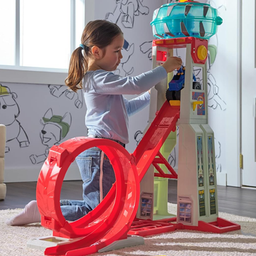 playset with a child interacting with a toy tower featuring a slide and loop playset with a child interacting with a toy tower featuring a slide and loop