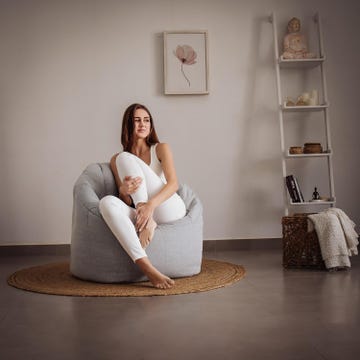 mujer sentada en un puf en el salon