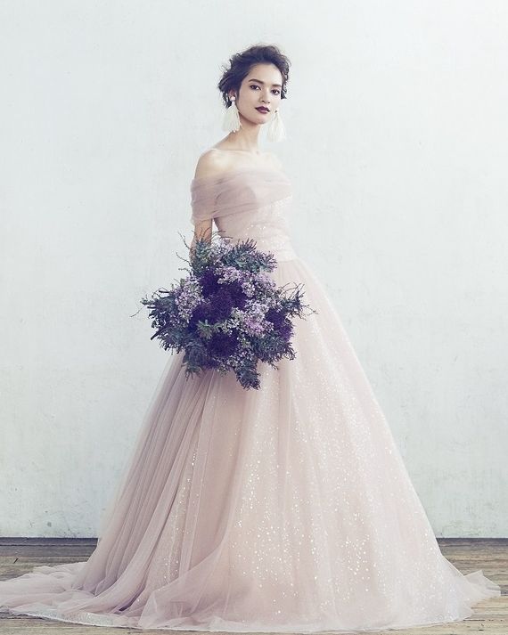 ハツコ エンドウ ウェディングスの淡いピンクのカラードレスを着たモデルの写真。