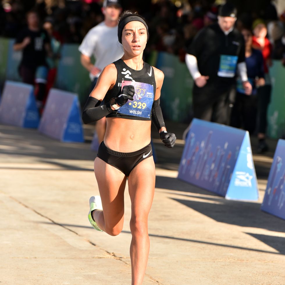 a woman running down the finish straight at a marathon