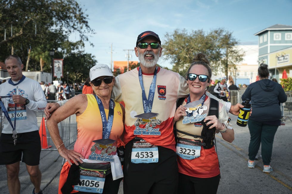 participants holding medals after completing a half marathon event space coast marathon half marathon