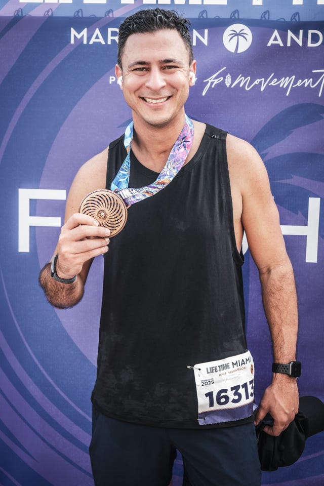 participant holding a medal at a marathon event farouk gomati guillain barre syndrome