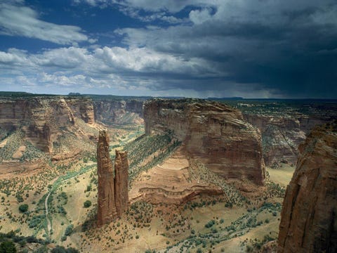 Zo ver het oog rijkt strekken zich de verweerde rotsformaties van de Canyon de Chelly uit een nationaal monument in Arizona Het park is uniek in de VS want het bestaat geheel uit land van het Navajovolk Volgens het geloof van de Navajo woonde een godheid genaamd de Spinnenvrouw op de top van de Spider Rock de zandstenen monoliet op de voorgrond van de foto Zij verorberde kinderen die zich hadden misdragen waardoor de top van de rotspilaar wit werd door hun verbleekte botten