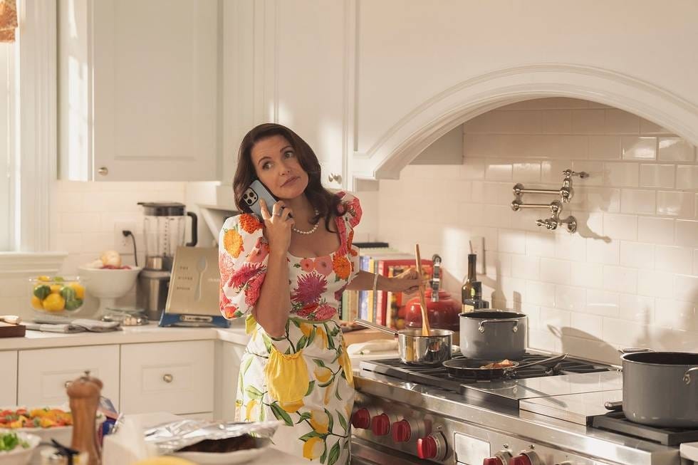 A person cooking in a bright kitchen while on the phone.