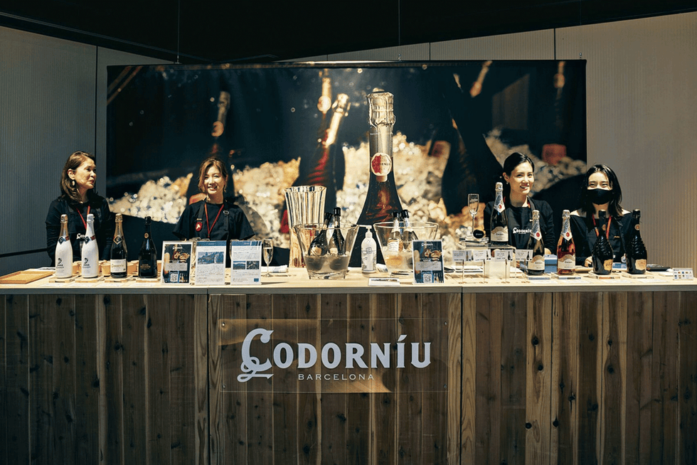 a group of people sitting at a bar with wine bottles