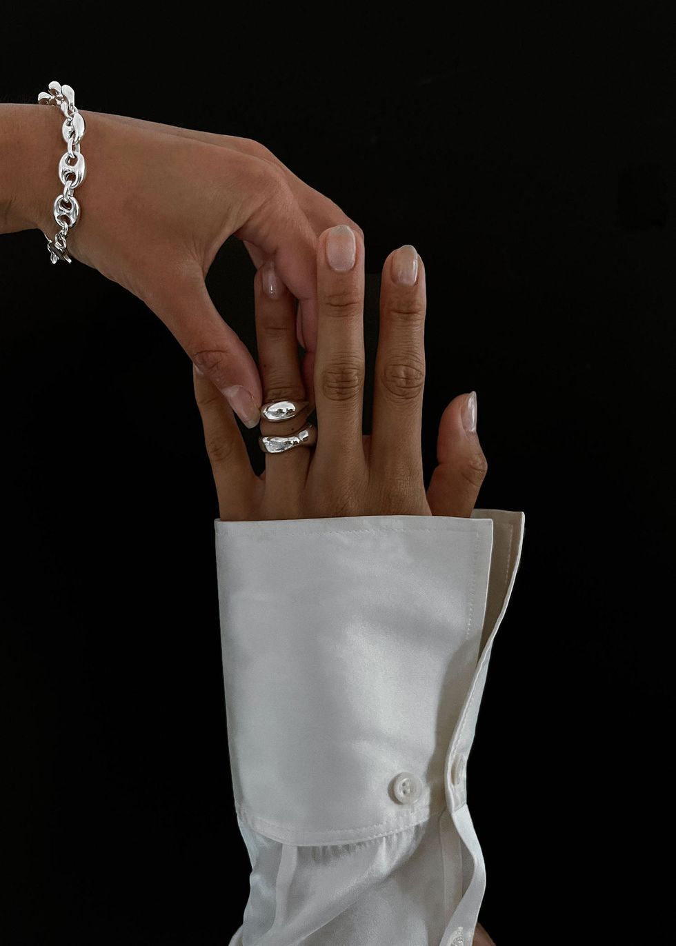 a pair of hands with rings