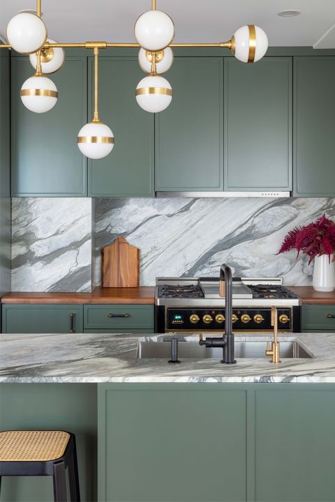 green kitchen, green cabinets, marble countertops, black faucet, black and brown bar stools, marble back splash