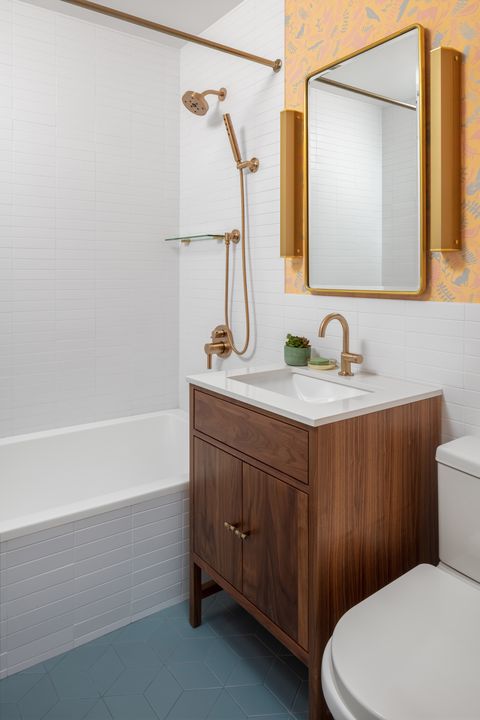 bathroom, white subway tiles, blue floor tiles, wooden cabinets, white sink, copper faucet