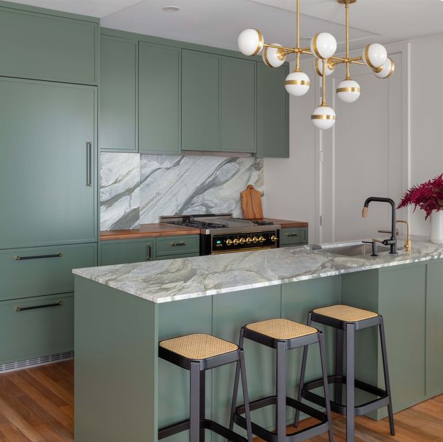 green kitchen, green cabinets, white ceiling light, marble countertops, marble back splash