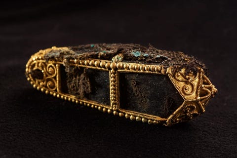 Deze gouden hanger nog steeds bedekt door restanten van de stof die er ter bescherming omheen was gewikkeld bevatte ooit mogelijk een reliek van een heilige Hij maakte deel uit de van de schat van Galloway een enorme verzameling door de Vikingen buitgemaakte voorwerpen die rond de tiende eeuw nChr in Schotland werd begraven en in 2014 weer werd teruggevonden