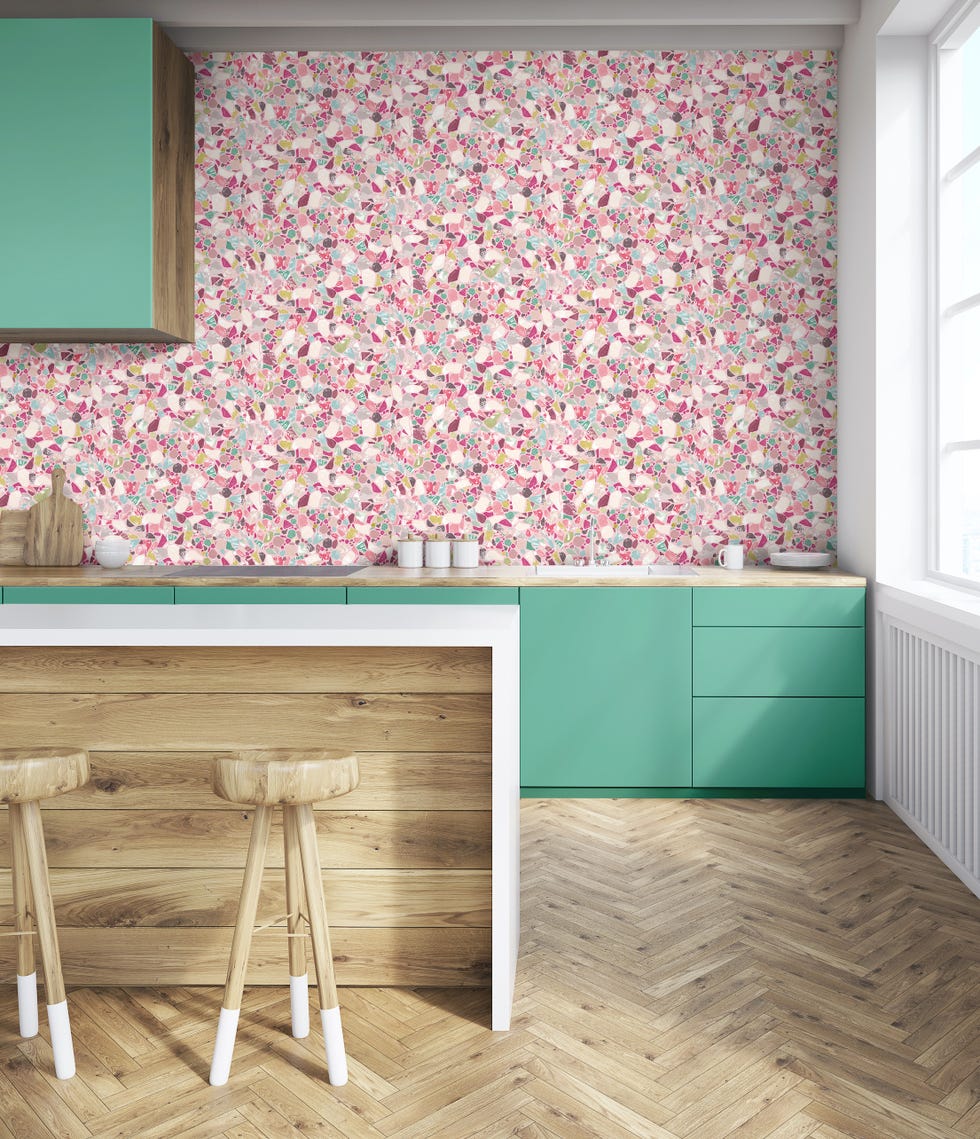 modern kitchen with parquet floor, green handleless cabinets and pink patterned wallpaper