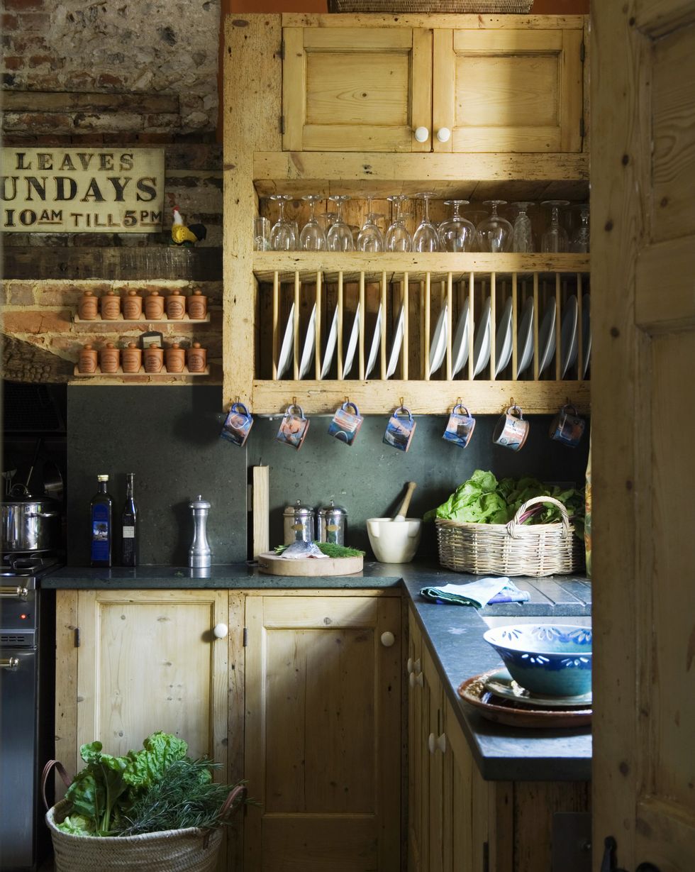 a rustic fitted kitchen with wooden cupboards and a built in plate rack