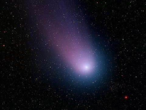 De komeet C2001 Q4 ook wel NEAT genoemd schijnt in blauw en paars licht terwijl hij in mei 2004 door de kosmos zoeft Op deze foto zijn de coma de kop van de komeet en zijn staart te zien naast ontelbare sterren Deze opname werd gemaakt met een telescoop van het Kitt Peak National Observatory bij Tucson Arizona