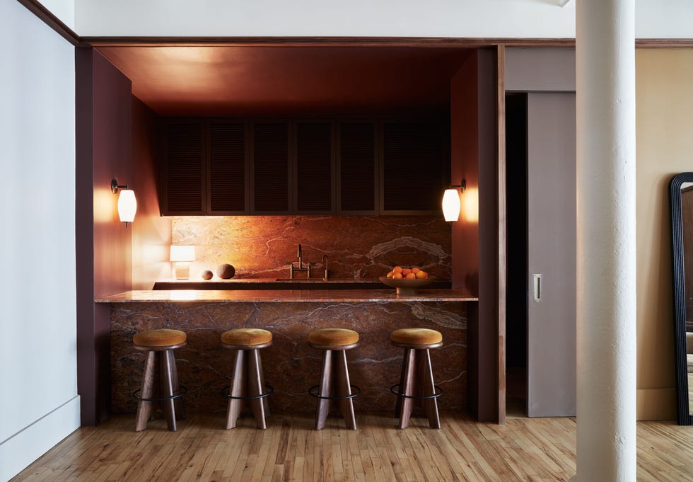 Contemporary kitchen bar area with stools and decorative items.