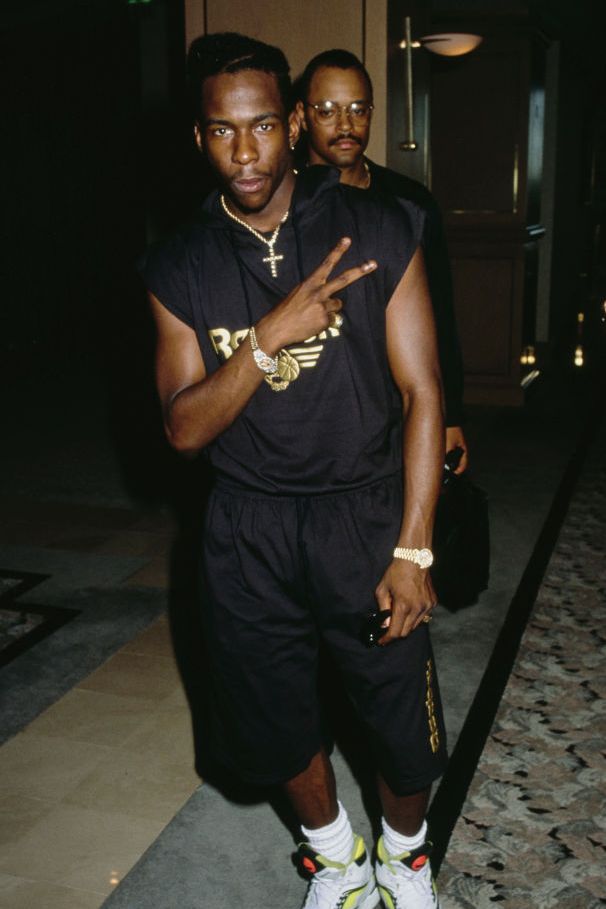 best 90s fashion trends, man wearing a black cap sleeve t shirt and black board shorts