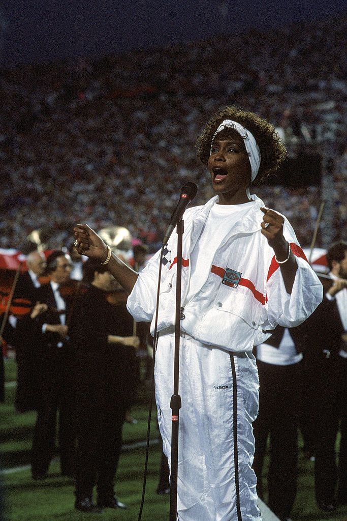 best 90s fashion trends, whitney houston wearing a white track suit at the super bowl