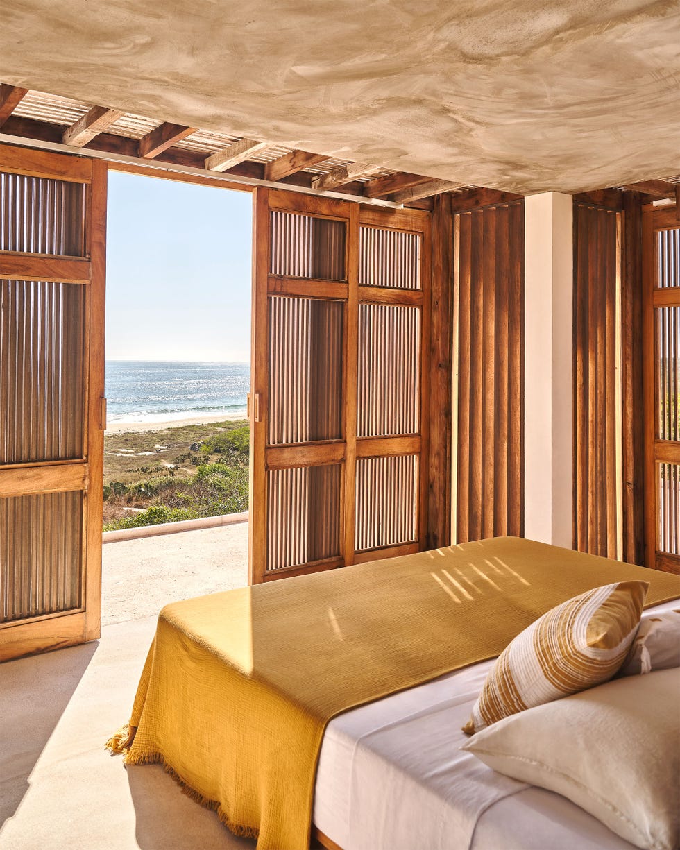 Cozy bedroom with open doors revealing an ocean view.