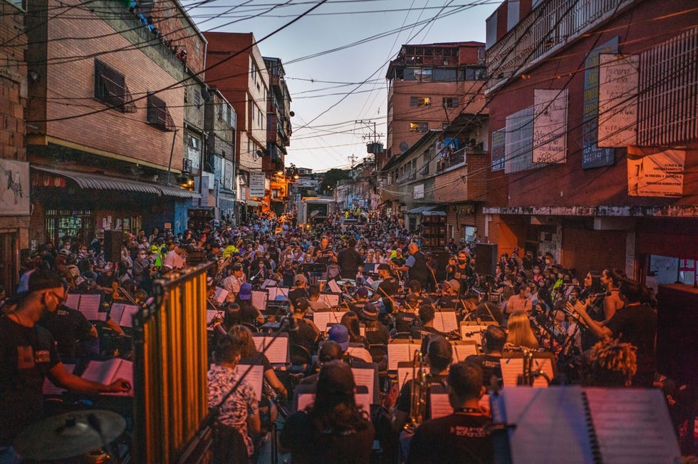 Caracas, Venezuela CARACAS VENEZUELALeden van het Orquesta Sinfnica Gran Mariscal de Ayacucho spelen muziek van hun nieuwe album Sinfona Desordenada Rommelige symfonietijdens een openluchtconcert op 12 november 2021 in de Venezolaanse hoofdstad Caracas Het album werd opgenomen tijdens de lockdown door 75 muzikanten die elementen van klassieke muziek combineerden met AfroCaribische ritmes