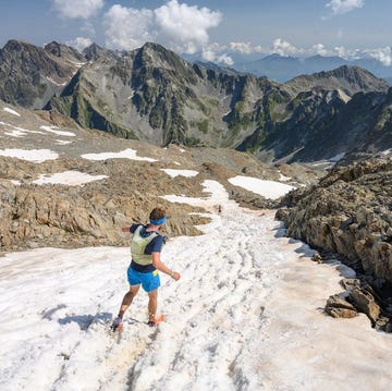 runner navigating a mountainous trail with snowy patches runner navigating a mountainous trail with snowy patches