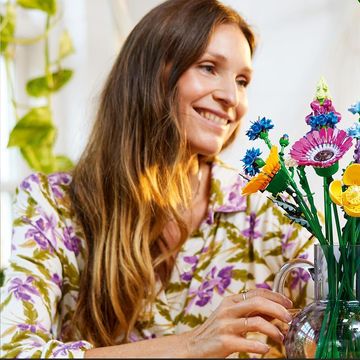 mujer con ramo de flores lego en la mano